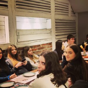 Grupa młodzieży przy stole w restauracji.