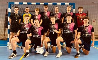 Zespół chłopców w strojach sportowych prezentujący medale i dyplom po zawodach.