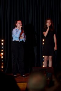 Dwie dziewczyny śpiewają na scenie. 