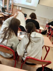 Uczniowie siedzą w klasie lekcyjnej