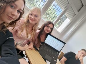 Trzy uczennice pokazujące ekran laptopa