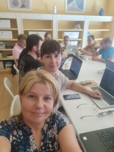 Uczestnicy szkolenia w sali przy biurkach z komputerami